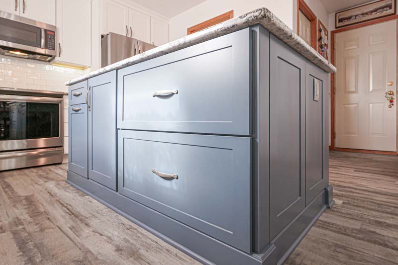 Grey cabinet handicap-accessible island in the middle of the kitchen.