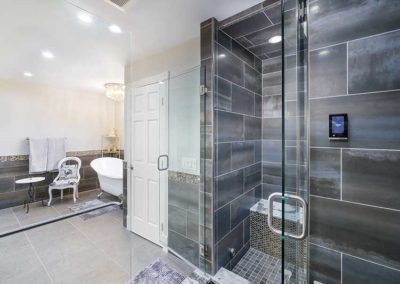 Bathroom with a smart temperature control tool and a wheelchair accessible shower with a seat.