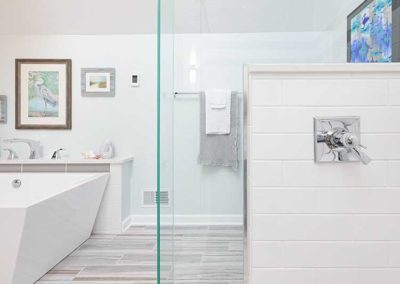 Bathroom with white bathtub and glass shower.