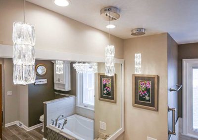 Master bathroom with a wide mirror, alcove bathtub and a toilet.