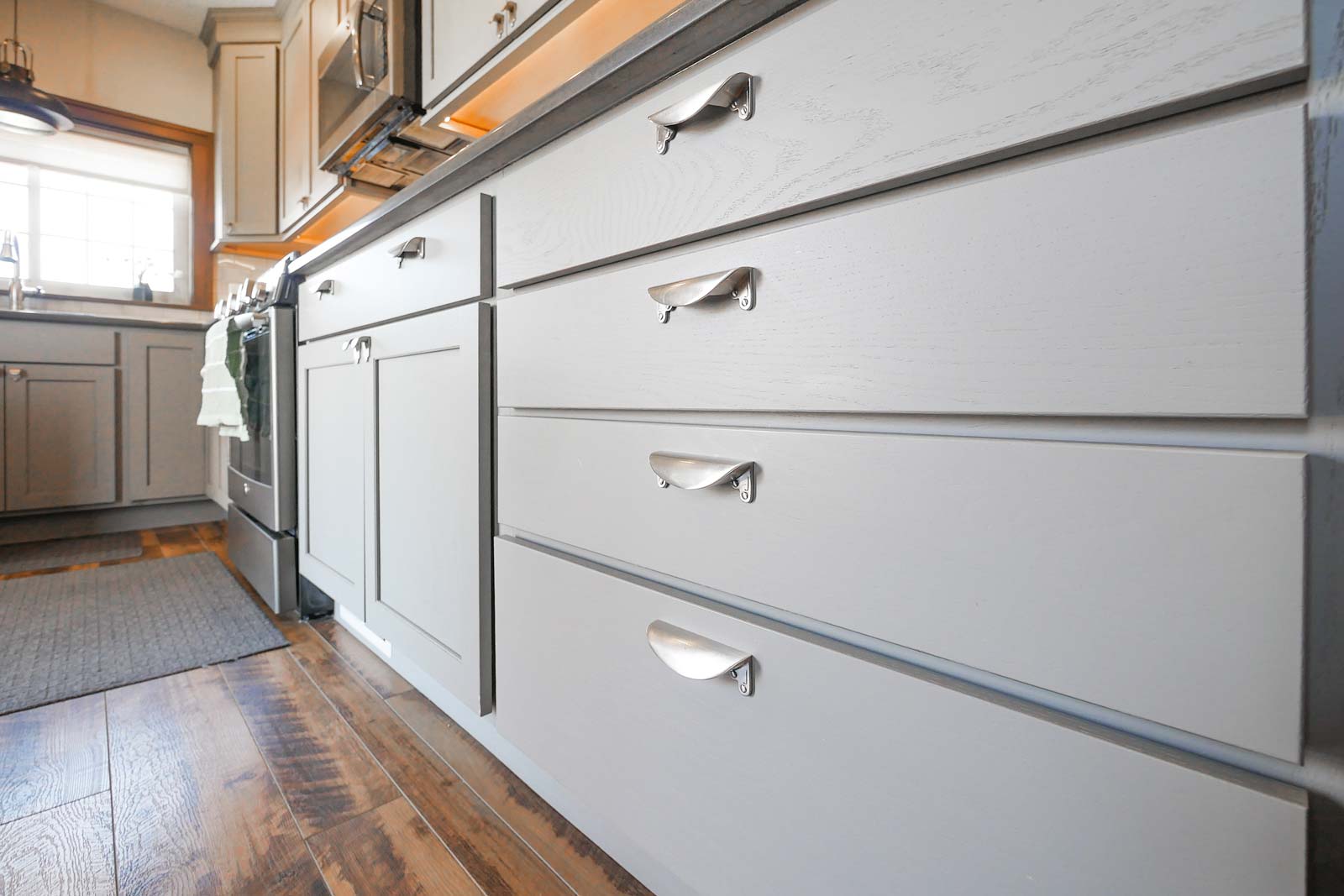 Grey kitchen cabinets with metal handles.