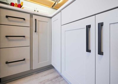 White kitchen cabinets with modern black handles.