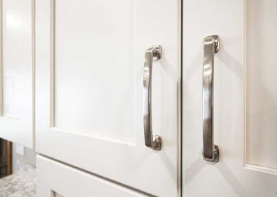 White kitchen cabinet doors with silver metal handles.