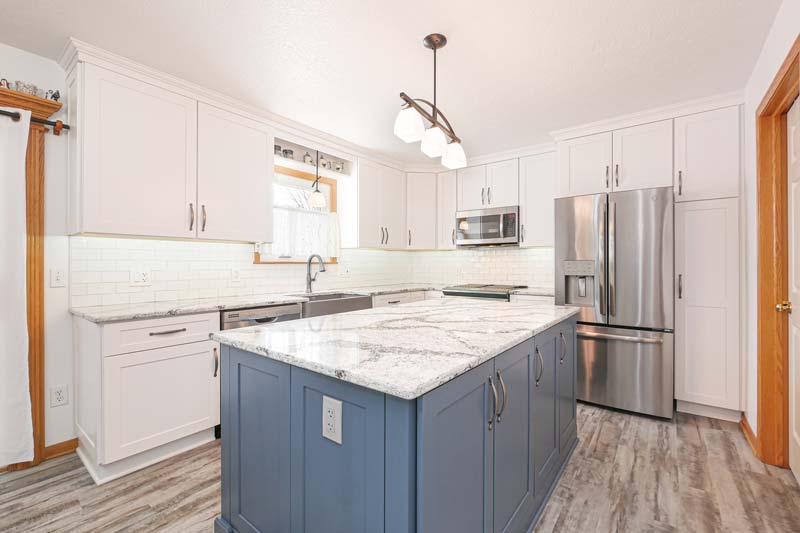 Kitchen island marble countertop with grey cabinets.
