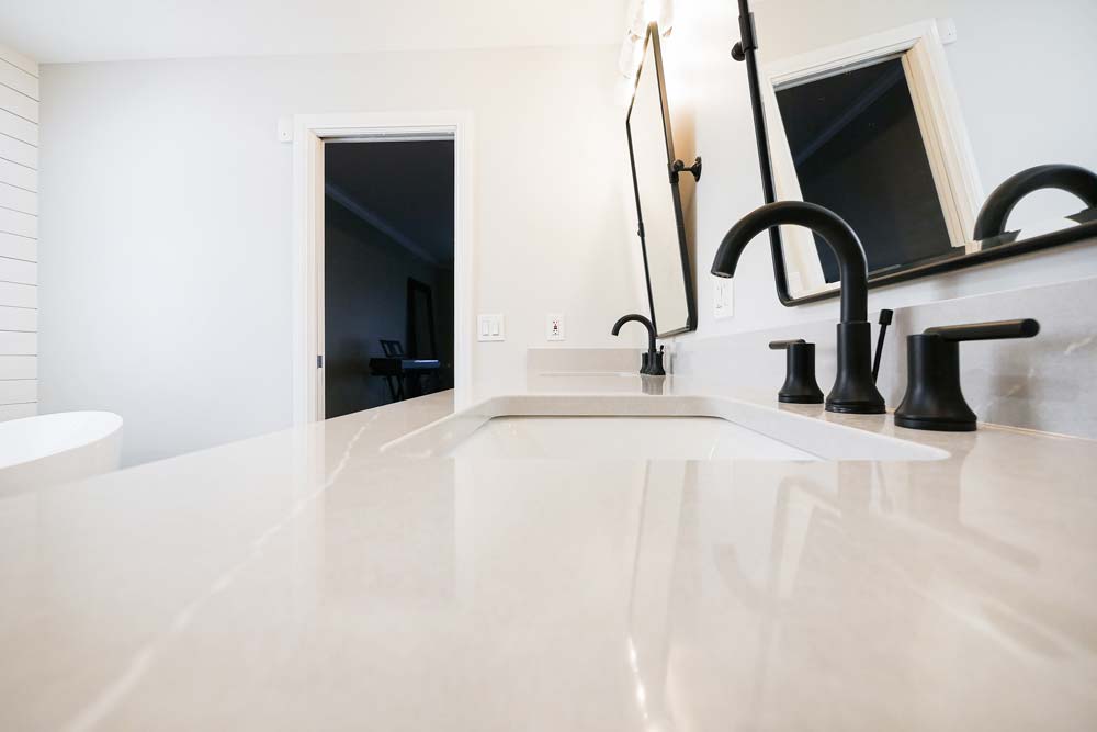 White marble bathroom countertop with black faucet.