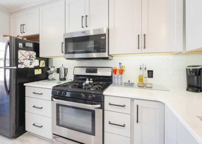 Kitchen with white cabinets and quartz countertops.