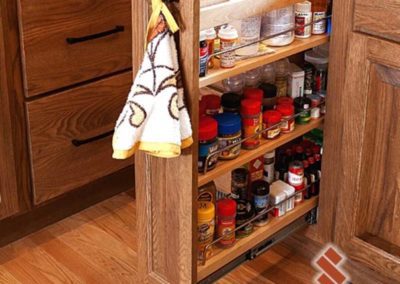 Unique storage space for spices and miscellaneous products inside wooden kitchen cabinets.