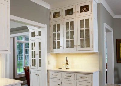 White kitchen cabinets extended to the ceiling with extra storage space.