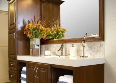 Dark wood bathroom cabinets with extra storage for towels.